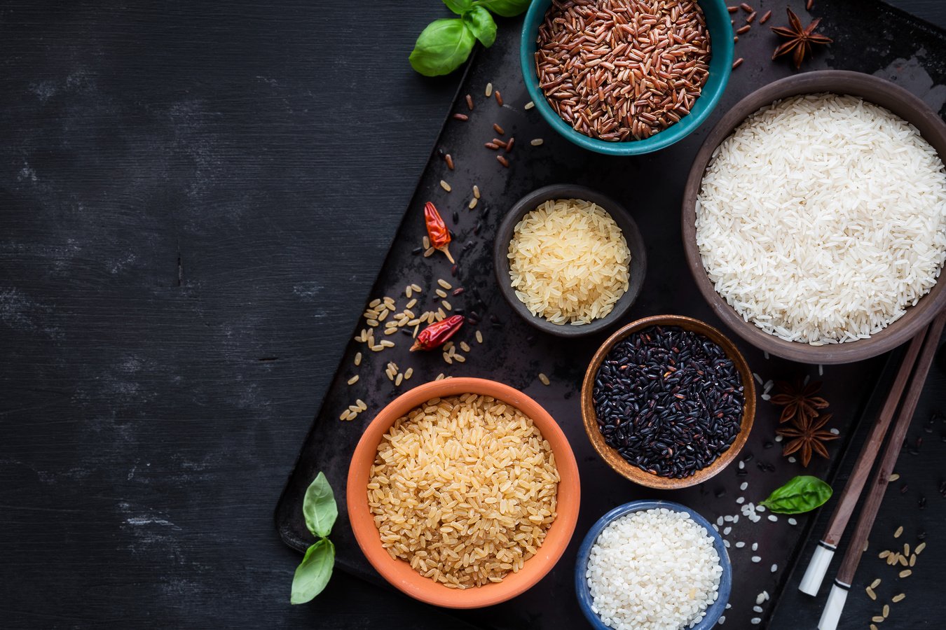 Variety of rice types in different bowls with copyspace