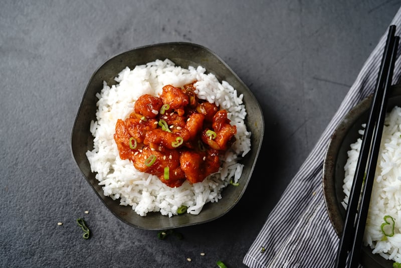 Homemade sweet and sour chilli chicken served with jasmine rice, selective focus